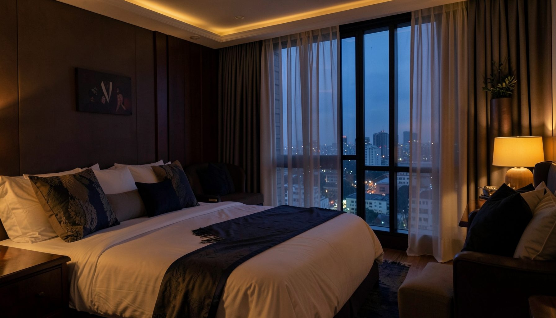 Softly lit luxury hotel suite at dusk in Mumbai, warm amber and deep navy tones, sheer curtains framing a city skyline